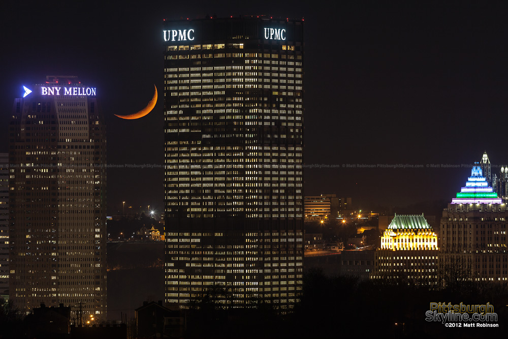 Crescent moon sets between the US Steel Tower and BNY Mellon Center on Light Up Night