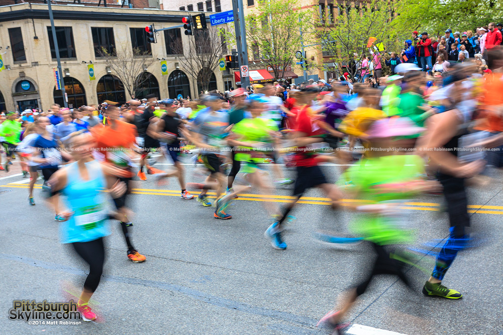 Runners blur past during the Pittsburgh Marathon