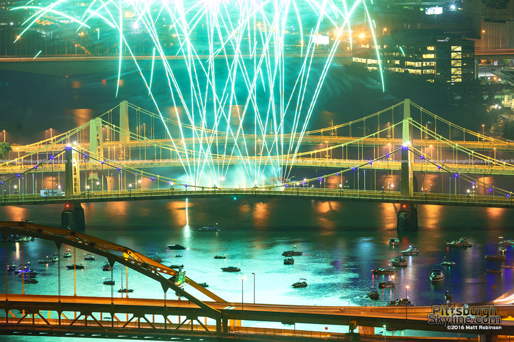 Fireworks shoot off of the Roberto Clemente Bridge with boats watching